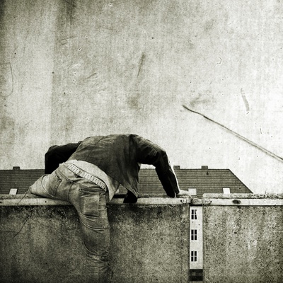 A Young Man Climbing Over A Wall by Jewgeni Roppel Pricing Limited Edition Print image