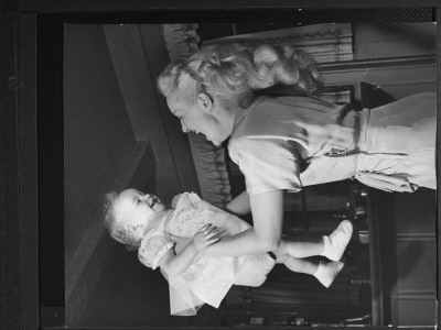 Betty Grable Joyfully Lofting Her Daughter In The Air During The Child's Birthday Celebration by Peter Stackpole Pricing Limited Edition Print image