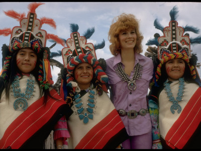 Jill St. John Wearing A Squash Blossom Necklace And Concha Belt, Surrounded By Navajo Indians by Michael Mauney Pricing Limited Edition Print image