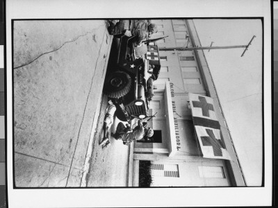 Firefight In Front Of Hospital; American G.I. Pushes Little Boy Under Jeep For Protection by Jack Lartz Pricing Limited Edition Print image