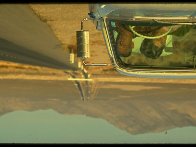 Gray Haired Couple Sleeping In Car On Side Of Desert Highway by Ralph Crane Pricing Limited Edition Print image