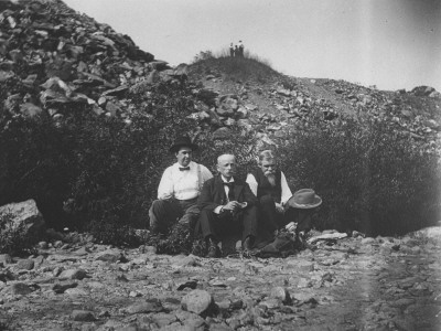 Three Well-Dressed Men Sitting In A Quarry During An Outing by Wallace G. Levison Pricing Limited Edition Print image