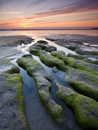 Sunset Over Strange Rock Formations On Beach At Westward Ho!, Devon, England by Adam Burton Pricing Limited Edition Print image