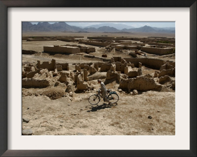 An Afghan Youth Rides His Bycicle By Houses by Musadeq Sadeq Pricing Limited Edition Print image