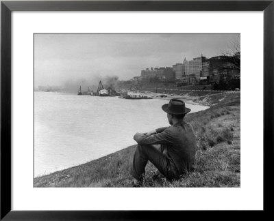 Young African American Boy Sitting On Memphis Riverbank Watching Boats On The Mississippi River by Ed Clark Pricing Limited Edition Print image