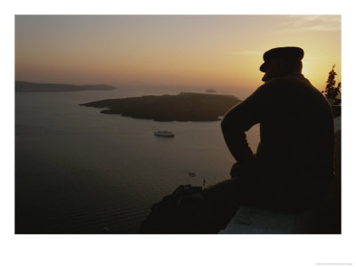 A Silhouetted Greek Man Enjoys A Sunset From A High Point On Thira by Tino Soriano Pricing Limited Edition Print image