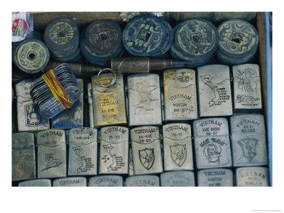 A Tray Full Of War Memorabilia Engraved Zippo Lighters, Dog Tags, Bullets, And Ancient Coins by Steve Raymer Pricing Limited Edition Print image