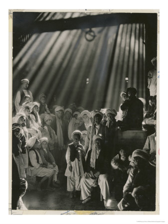 Rays Of Sunlight Shine On Men And Boys In A Crowded Warehouse by Maynard Owen Williams Pricing Limited Edition Print image