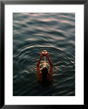 Woman Pouring Water During Morning Puja On Ganges, Varanasi, India by Anthony Plummer Pricing Limited Edition Print image