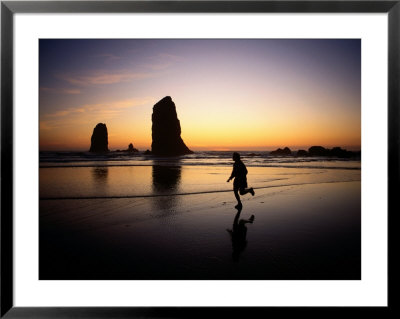 A Boy Runs Along Cannon Beach With Sea Stacks In The Background by Phil Schermeister Pricing Limited Edition Print image