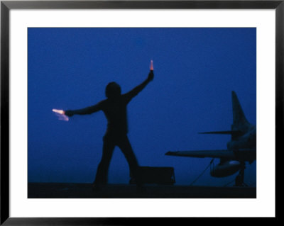A Ground Control Person Guides A Plane On An Aircraft Carrier by Bill Curtsinger Pricing Limited Edition Print image