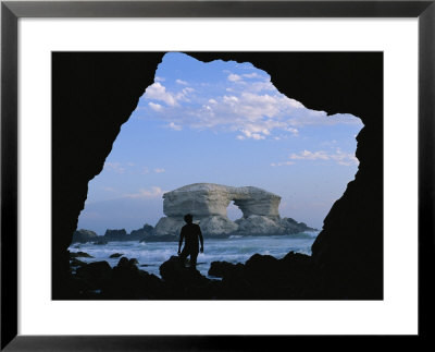 A Man Silhouetted Against La Portada Rock Arch On The Coast Of Chile by Joel Sartore Pricing Limited Edition Print image