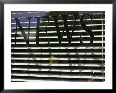 Afternoon Sun Casts Shadows Across The Word News Painted On A Window by Stephen St. John Pricing Limited Edition Print image