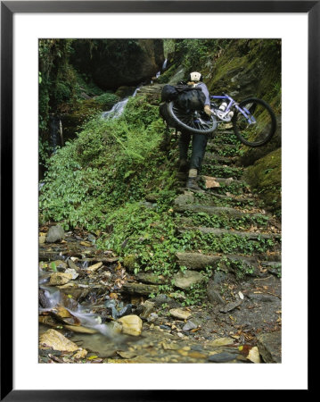 Woman Carries Mountain Bike Up Steep Stone Stairs Next To Stream by Mark Cosslett Pricing Limited Edition Print image