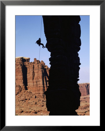 A Climber Rappels Down A Rock Formation In Monument Basin by Bill Hatcher Pricing Limited Edition Print image