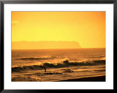 A Couple Frolicking In The Surf Off Kekaha Beach With Niihau Island In The Distance, Kauai, Hawaii by Ann Cecil Pricing Limited Edition Print image