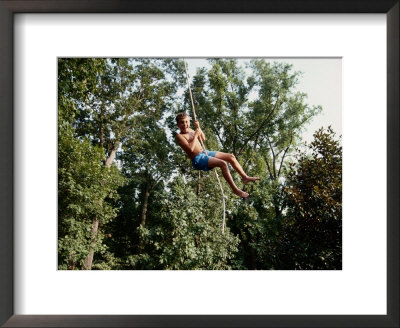 A Young Boy Takes A High Arc On A Rope Swing by Stephen St. John Pricing Limited Edition Print image