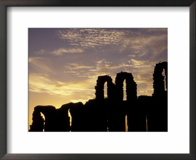 Silhouetted Ruins Of A Roman Amphitheatre At Sunset, Tunisia by Michele Molinari Pricing Limited Edition Print image
