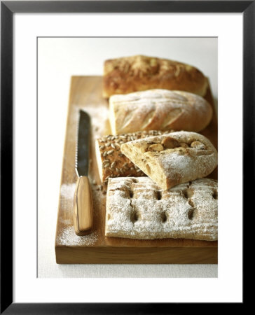 Assorted Loaves On Wooden Chopping Board by Michael Paul Pricing Limited Edition Print image