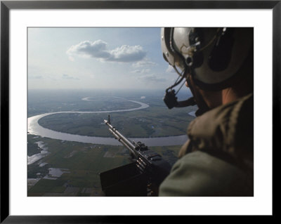 Machine Gunner Scanning For Hostiles While His Helicopter Is On Patrol Over The Mekong Delta by Larry Burrows Pricing Limited Edition Print image