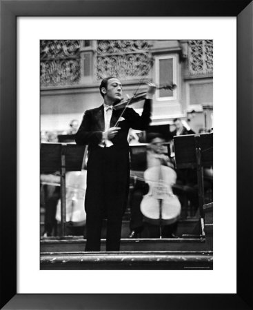 Violin Virtuoso Jascha Heifetz With Violin And Bow During Concert, As Cellists Play Behind Him by Alfred Eisenstaedt Pricing Limited Edition Print image