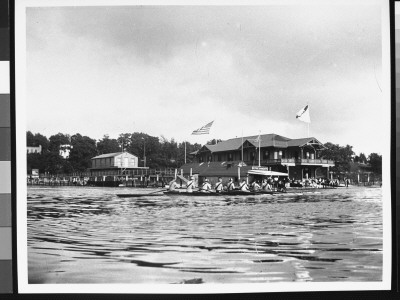 A Crew Team Rowing By Wooden Buildings On The Harlem River, As Taken From Another Boat by Wallace G. Levison Pricing Limited Edition Print image