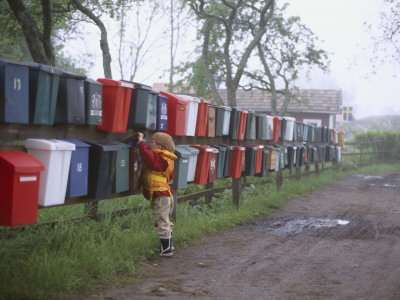 A Boy Checking For Mail In On Of Many Mailboxes Hanging On A Fence by Helena Bergengren Pricing Limited Edition Print image