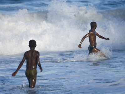 Two Boys Playing In The Surf On The Beach, Manakara Town, East Coast Of Madagascar by Inaki Relanzon Pricing Limited Edition Print image