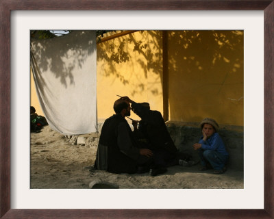 A Barber Cuts The Beard Of A Client In His Barber Post In Kabul, Afghanistan, October 1, 2006 by Rodrigo Abd Pricing Limited Edition Print image
