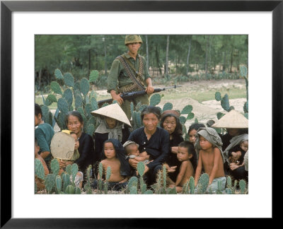 Marine Guarding Mostly Old People And Children Who Are Resting On Their Way To A Refugee Collection by Paul Schutzer Pricing Limited Edition Print image
