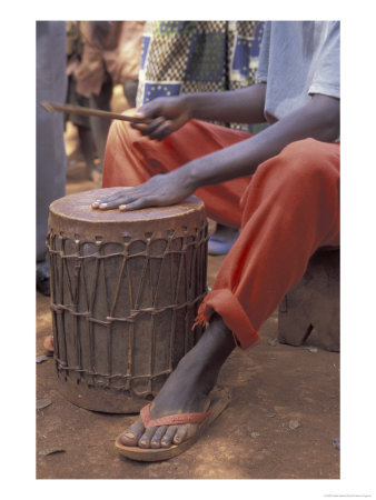 Playing A Congolese Drum In A Congolese Refugee Camp, Tanzania by Kristin Mosher Pricing Limited Edition Print image