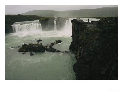 A Lone Visitor Watches The Cascades Of Godafoss Waterfall by Sisse Brimberg Pricing Limited Edition Print image
