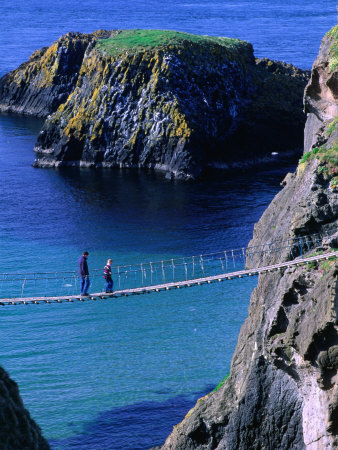 People Walking Across Carrick-A-Rede Rope Bridge To Small Rocky Island, Antrim, Northern Ireland by Gareth Mccormack Pricing Limited Edition Print image