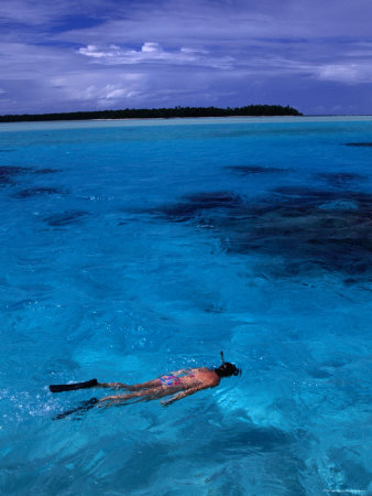 Snorkeller In The Clear Blue Waters Off Aitutaki In The South Pacific, Cook Islands by Lee Foster Pricing Limited Edition Print image