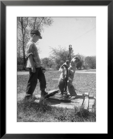 Two Boys Getting Water From A Pump At Rural School by Thomas D. Mcavoy Pricing Limited Edition Print image
