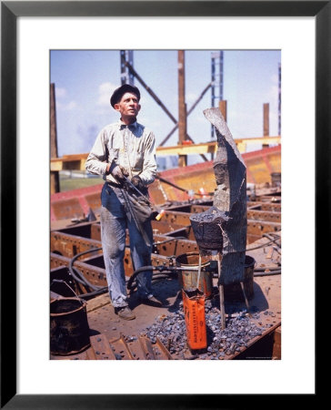 War Worker Holding Red Hot Metal Piece With Tongs At Shipyard by George Strock Pricing Limited Edition Print image