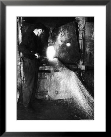 Glass Blower Heating Up Molten Glass Prior To Blowing A Glass Piece At Corning Glass Plant by Margaret Bourke-White Pricing Limited Edition Print image