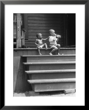 African American Boys At Top Of Stairs As Older Boy Is Drinking Soda And Younger One Reaches For It by Alfred Eisenstaedt Pricing Limited Edition Print image