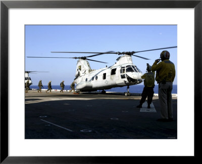 Personnel Walk Into The Rear Of A Ch-46E Sea Knight Helicopter by Stocktrek Images Pricing Limited Edition Print image