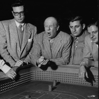 Star Bert Lahr, Clowning Around As He Tosses His Dice At The Table by Loomis Dean Pricing Limited Edition Print image