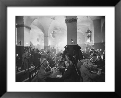 Interior Of Munich Beer Hall, People Sitting At Long Tables, Toasting by Ralph Crane Pricing Limited Edition Print image