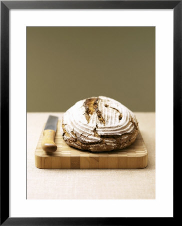 Bauernbrot (German Farm Bread) On Wooden Board With Knife by Jost Hiller Pricing Limited Edition Print image