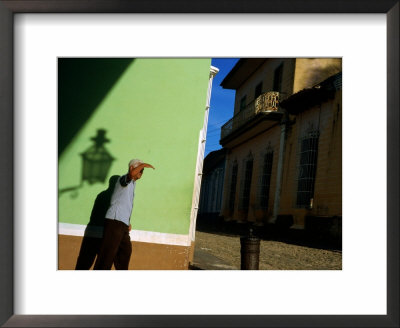 Man Shielding Eyes Whilst Walking Past Wall, Sancti Spiritus, Cuba by Corey Wise Pricing Limited Edition Print image