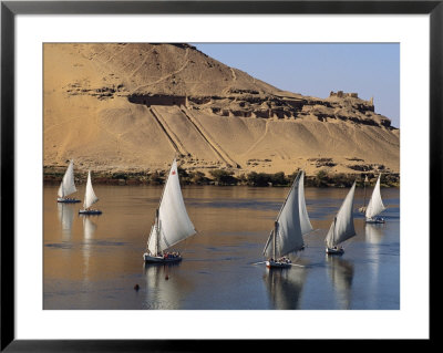 Feluccas On The Nile Sail Past The Tombs Of Qubbat Al Hawa At Aswan by Kenneth Garrett Pricing Limited Edition Print image