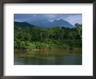 A Canoe Dwarfed By The El Almandro River And Surrounding Rain Forest by Stephen Alvarez Pricing Limited Edition Print image