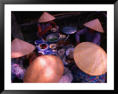 Women In Traditional Conical Hats Sitting Down To Meal At Market, Hoi An, Vietnam by John Banagan Pricing Limited Edition Print image