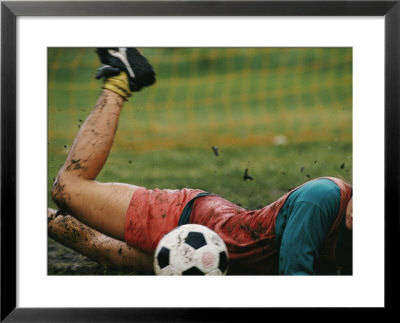 A Soccer Player Lands In The Mud In An Attempt To Field The Ball by Dugald Bremner Pricing Limited Edition Print image