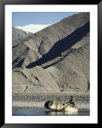 A Boatman Rows A Yak Skin Boat Across The Lhasa River by Gordon Wiltsie Pricing Limited Edition Print image