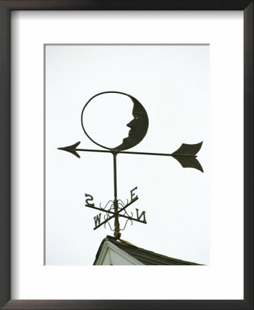 A Man-In-The-Moon Weather Vane On A Roof Top by Darlyne A. Murawski Pricing Limited Edition Print image