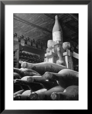 Dust Covered Wine And Brandy Bottles Lying On Racks In A Wine Cellar by Nina Leen Pricing Limited Edition Print image